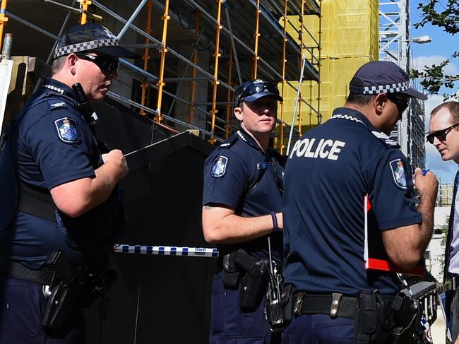 Police guard the entrance to an apartment complex (right) where the the body of a 49 year-old woman was found in Toowong, Brisbane, Tuesday, Dec. 8, 2015. The body of her 11 year-old daughter was found in the nearby suburb of Auchenflower. (AAP Image/Dan Peled) NO ARCHIVING