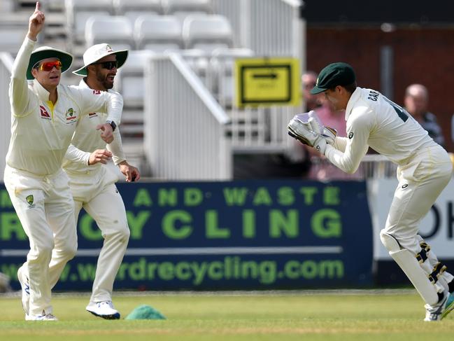 Australia's Steve Smith (L) celebrates as Australia's Alex Carey (R) takes the wicket of Derbyshire's Anuj Dal. Picture: Paul Eellis/AFP