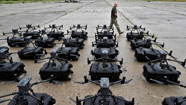 A military operator walks past 300 reconnaissance drones, bought in the frame of the program 'The Army of Drones' set up ready for test flights in the Kyiv region, this week. Picture: AFP