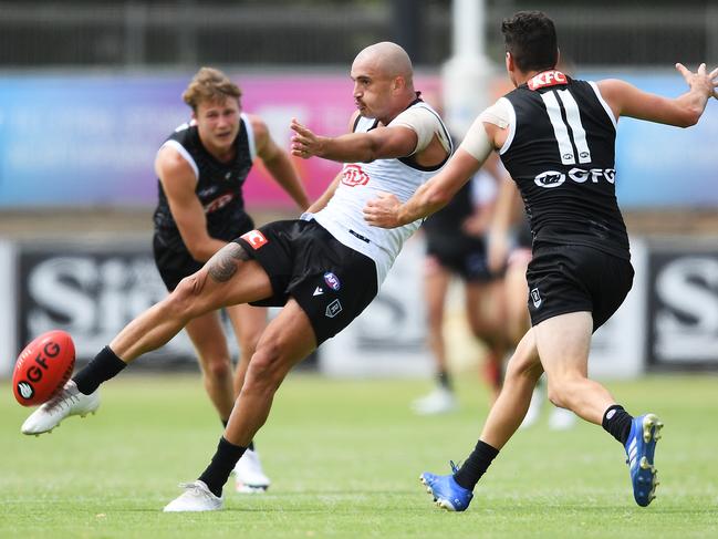 ADELAIDE, AUSTRALIA - FEBRUARY 13: Sam Powell-Pepper of Port Adelaide kicks past Tom Rockliff of Port Adelaide  during the Port Power AFL trial match at Alberton Oval on February 13, 2021 in Adelaide, Australia. (Photo by Mark Brake/Getty Images)