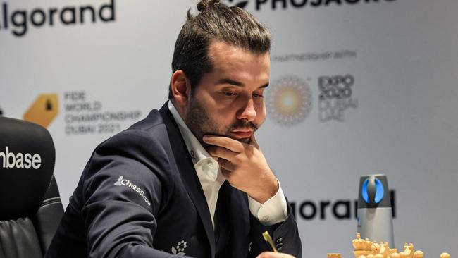 Russia's grandmaster Ian Nepomniachtchi writes down his move during his game five match against Norway's grandmaster Magnus Carlsen. Picture: AFP