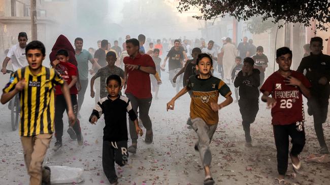 Palestinian children run as they flee from Israeli bombardment in Rafah in the southern Gaza Strip on Monday. Picture: AFP