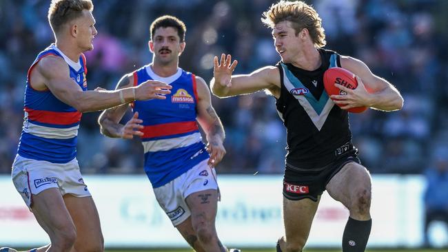 Port Adelaide’s Jason Horne-Francis breaks clear of the Western Bulldogs’ Adam Treloar (left) and Tom Liberatore at Adelaide Oval on Saturday. Picture: Mark Brake/Getty Images