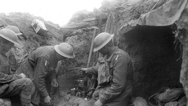 Three soldiers warm a mess tin of tea over a candle in the reserve line during the fighting near Bullecourt. Photo: Australian War Memorial  Photo: Australian War Memorial