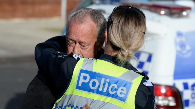 A relative of Mr van Bree is comforted by police at the scene of the fatal house fire. Picture: Andrew Henshaw