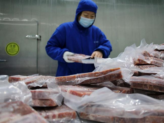 A worker packaging frozen steak at a processing plant in China's Shandong province. Chances that COVID-19 emerged in Wuhan because of imported frozen food are "very low", international health experts said. Picture: AFP