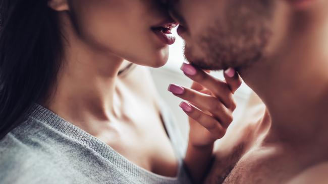 Close-up of young romantic couple is kissing and enjoying the company of each other at home.