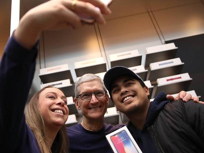 Apple Chief Executive Tim Cook, centre, poses for a selfie with customers during the debut of the iPhone X. Picture: Justin Sullivan