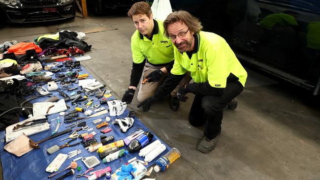 Sharps Australia chief operating officer Mark Friske and Sharps vehicle safety inspector Mike M clear out a stolen vehicle. Picture: David Clark