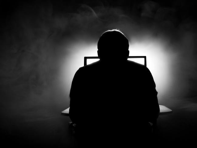 Man in front of computer. Dark night room with smoke. Man on computer. Sillhouette. Internet dating. From behind. iStock-862022082.jpg Photo: iStock