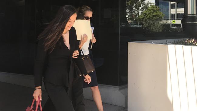 Rebecca Jane Klodinsky, hiding her face behind a manila folder, pleaded guilty to stealing in the Southport Magistrates Court on February 22, 2021. Picture: Jodie Callcott.