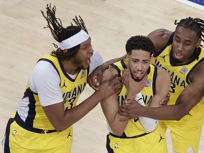 Indiana Pacers guard Tyrese Haliburton (0) is mobbed by teammates as he makes a choking motion after hitting a shot against the New York Knicks. Picture: AP/Adam Hunger