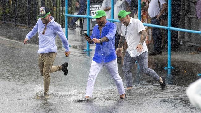 Punters splash their way around the track at the Gold Coast Turf Club. Picture: Richard Walker