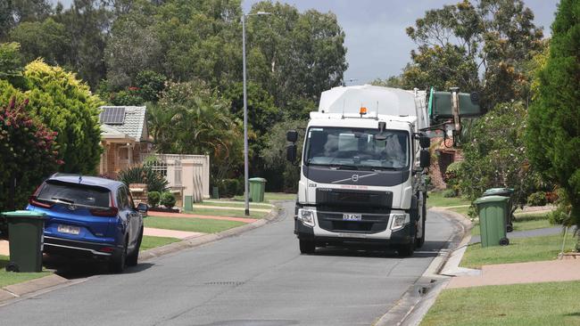 A truck collects rubbish on Greenwich Court in Robina, its passage aided by the fact a nearby car has been parked with two wheels up and two down. Picture: Glenn Hampson.