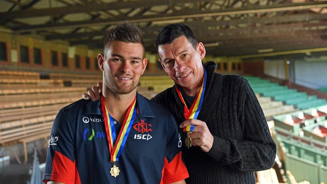 Mitch Grigg and his dad Chris, who has MND, with his Magarey Medals at Norwood Oval. Grigg has experienced major success throughout his career but is still chasing more at Lobethal. Picture: Tom Huntley