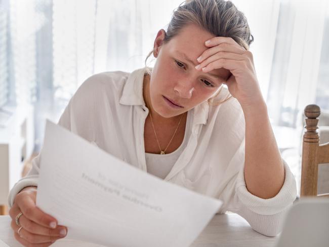 MONEY ISTOCK -  Woman looking worried holding paperwork at home. She is reading a financial bill or a letter with bad news. She looks very stressed and upset. There is a laptop computer on the table Picture: Istock