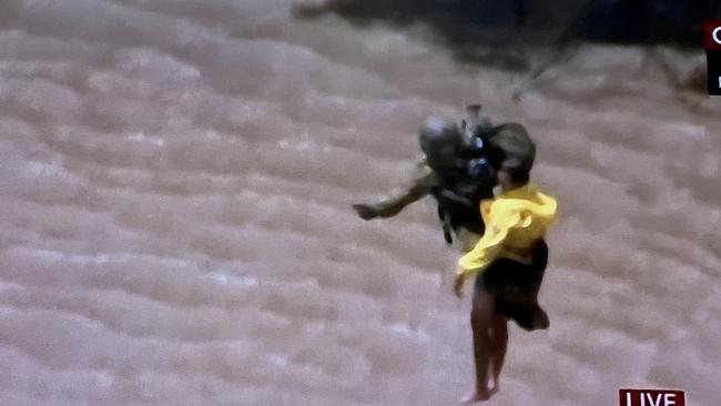 Sky TV frame grabs of a live rescue from the top of a in Lismore by the defence force - a third person is pictured being airlifted to a helicopter