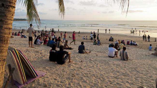 Sunset at Kuta Beach in Bali. Many people can be seen sitting on the beach watching the last rays of light before the sun descends for another day. Picture: iStock