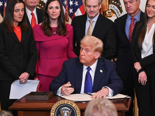 US President Donald Trump signs the Laken Riley Act in the East Room of the White House in Washington, DC, January 29, 2025. The Laken Riley Act -- which mandates the detention of undocumented immigrants charged with theft-related crimes -- is named for a 22-year-old student murdered by a Venezuelan man with no papers who was wanted for shoplifting. (Photo by ROBERTO SCHMIDT / AFP)