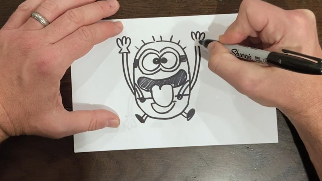 Step 21: draw the minions arms upwards. Don’t forget his fingers and gloves.