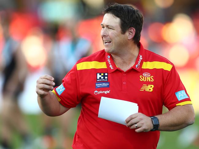 GOLD COAST, AUSTRALIA - JUNE 19: Suns coach Stuart Dew talks to players during the round 14 AFL match between the Gold Coast Suns and the Port Adelaide Power at Metricon Stadium on June 19, 2021 in Gold Coast, Australia. (Photo by Chris Hyde/Getty Images)