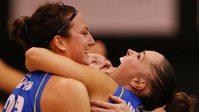 Kelsey Griffin (left), Kristy Harrower and Kelly Wilson (right) celebrate Bendigo Spirit winning the 2014 WNBL grand final.