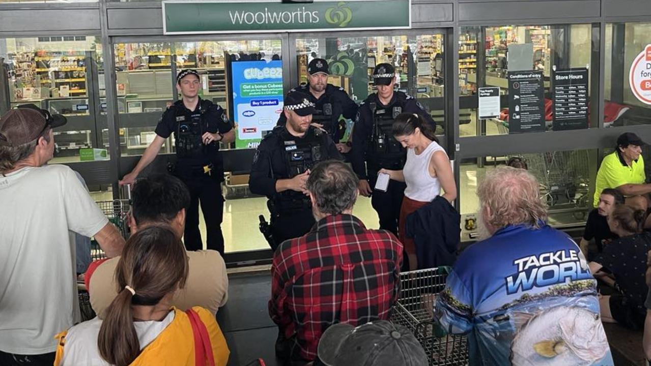 About 200 locals were lined up for food and supplies outside Woolworths in Ingham with police at the door to supervise. Picture: Cameron Bates