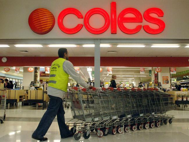 An employee collects shopping trolleys outside a Coles supermarket  in Chatswood, Sydney on 16 Aug 2006 : PicAndy/Shaw /Bloomberg /News - supermarket entrance sign signs logo logos