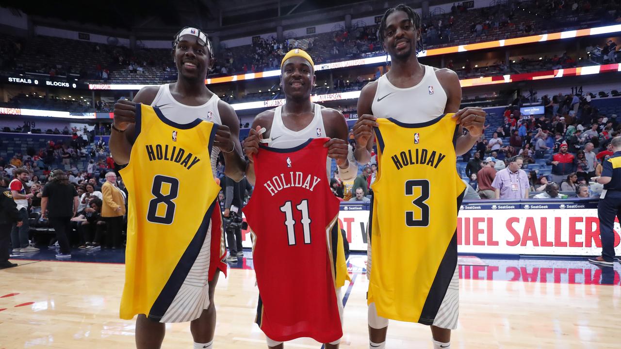 Jrue, Aaron and Justin Holiday swap jerseys after being the first trio of brothers to play together in an NBA game on Sunday. (AP Photo/Gerald Herbert)