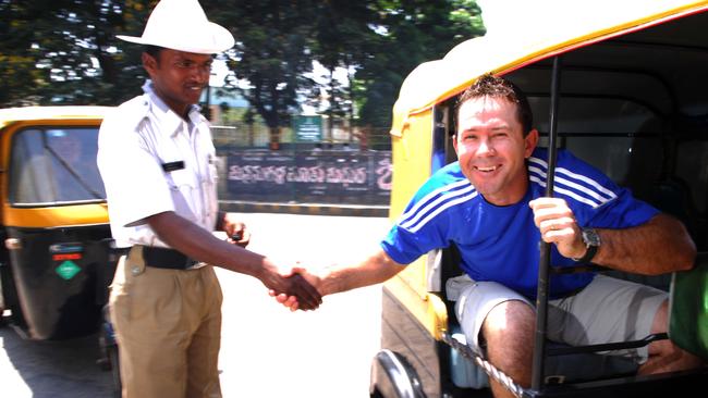 Australian cricket captain Ricky Ponting shakes hands with a traffic policeman while travelling around the streets of Bangalore, India, in an autorickshaw. The policeman stopped freeway traffic so Ponting could get to a photo shoot.