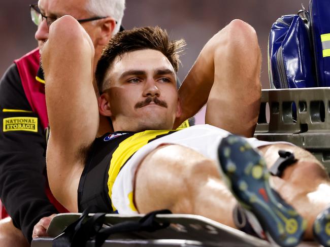 MELBOURNE, AUSTRALIA - MARCH 14: Josh Gibcus of the Tigers leaves the field on a stretcher during the 2024 AFL Round 01 match between the Carlton Blues and the Richmond Tigers at the Melbourne Cricket Ground on March 14, 2024 in Melbourne, Australia. (Photo by Dylan Burns/AFL Photos via Getty Images)