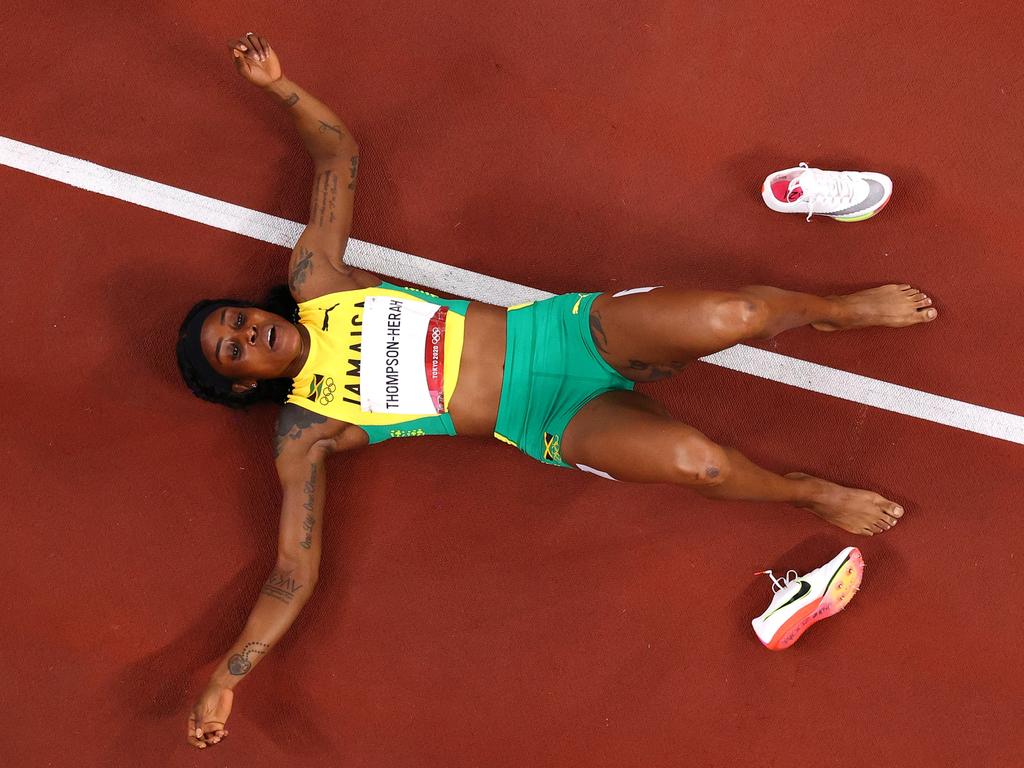 Jamaican Women’s 200m gold medallist Elaine Thompson-Herah kicks off the shoes after her win. Picture: Richard Heathcote/Getty Images