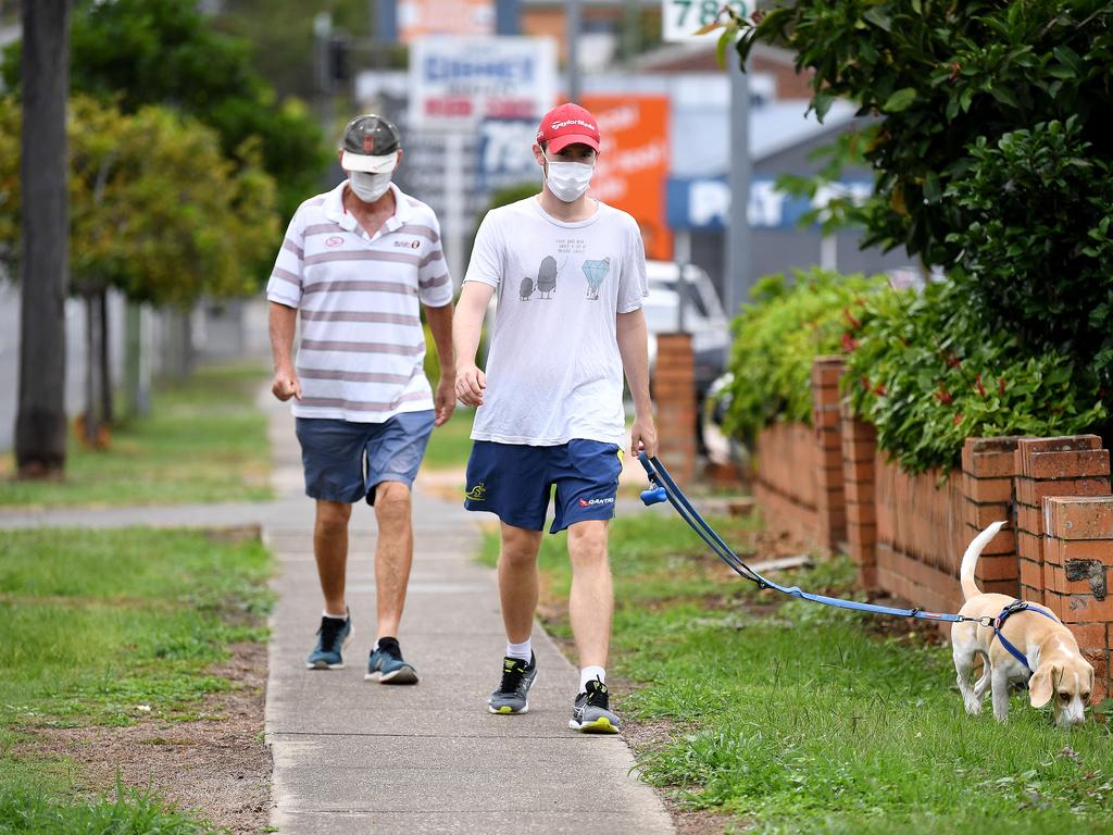 People wear face masks on a morning walk around Greenslopes. Picture: NCA NewsWire/Dan Peled.