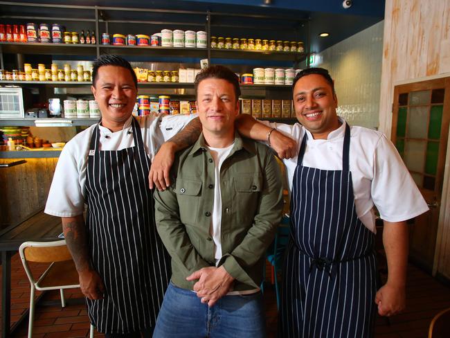 Oliver with Parramatta Jamie’s Italian chefs Darwin Abobo and Gurginder Singh. Picture: Phil Rogers