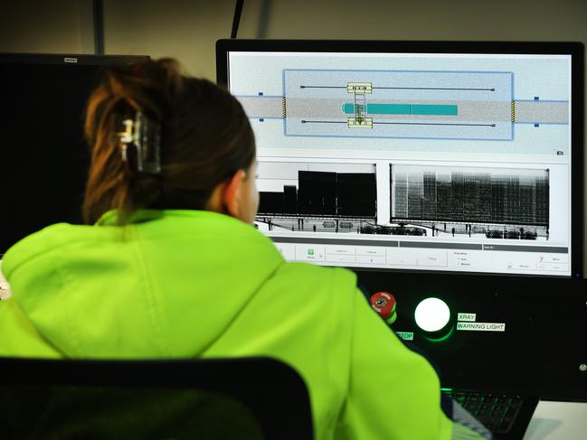 An ABF officer watches the X-ray screening of a container on a truck for anomalies. Picture: David Caird