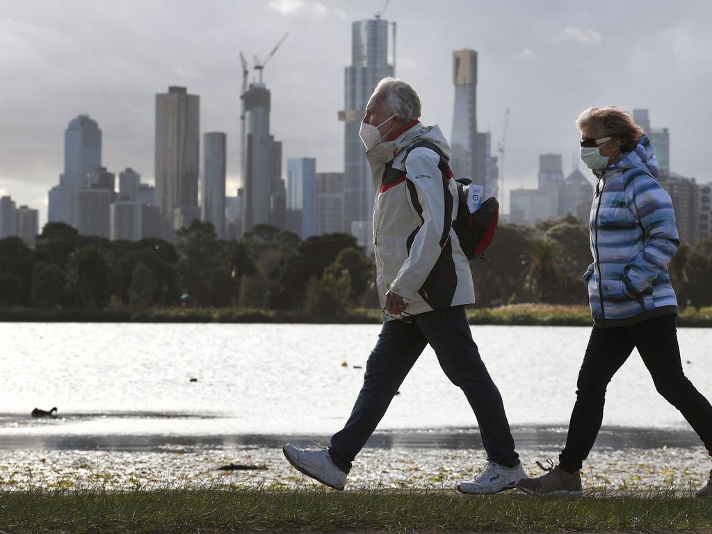 People walk along Albert Park lake in Melbourne on July 13. Picture: William West/AFP