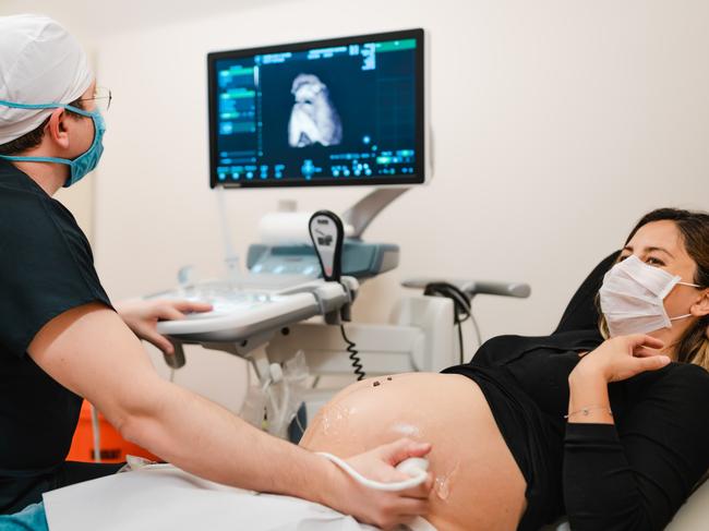 Pregnant woman watching her baby on the ultrasound