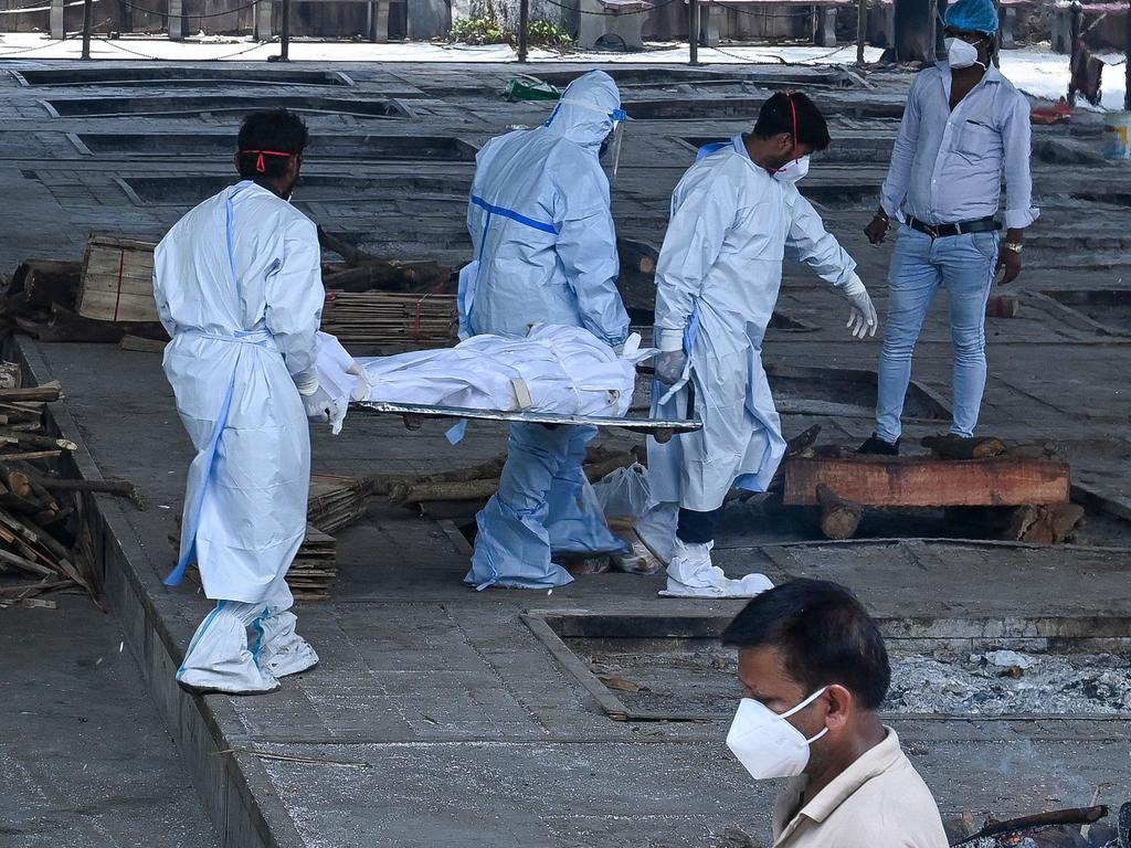 Ambulance staff carry a dead body for cremation, as businesses spring up to cope with the overflow. Picture: AFP