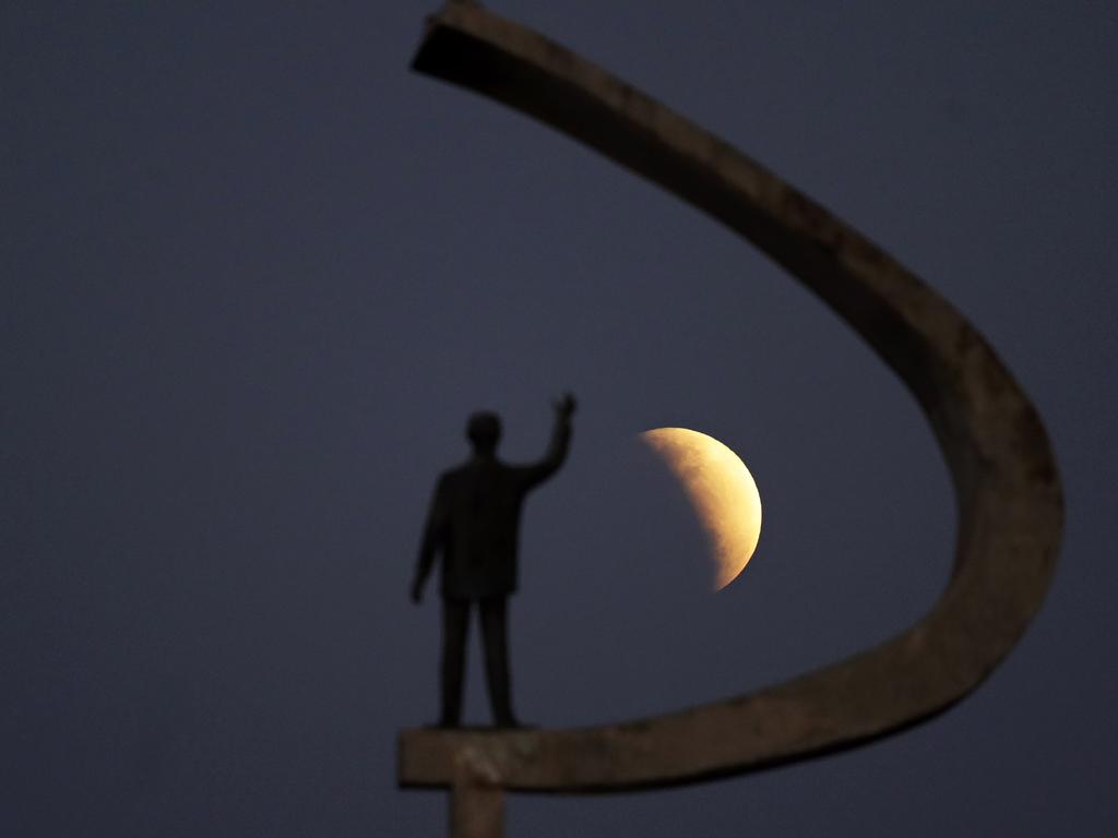 A statue of the Brazil's former President Juscelino Kubitschek, founder of Brasilia, stands during a partial lunar eclipse in the skies over Brasilia, Brazil, Tuesday, July 16, 2019. The partial lunar eclipse seen all over Brazil came the same day as the 50th anniversary of moon landings. (AP Photo/Eraldo Peres)