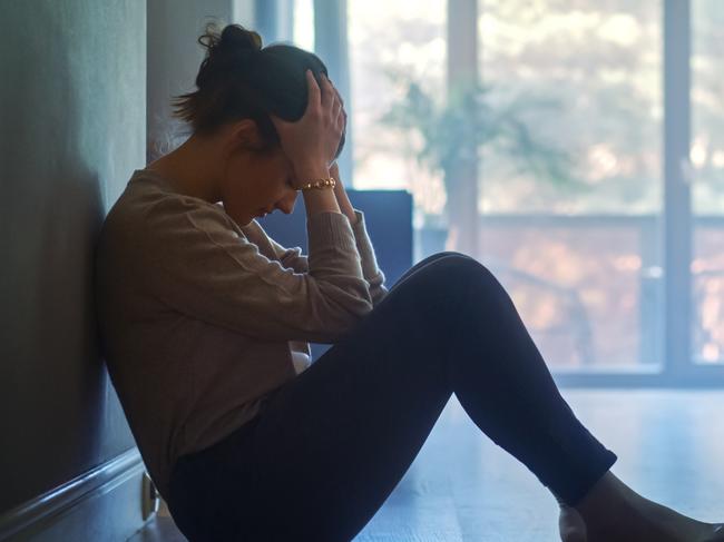 istock generic:  woman, abuse, DV, domestic violence, harassment, sexual harassment.   Sad Young Woman Sitting on the Floor In the Hallway of Her Appartment, Covering Face with Hands. Atmosphere of Depression, Trouble in Relationship, Death in the Family. Dramatic Bad News Moment . Picture: istock