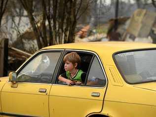 One of the Collier children sits in the Gemini among the ruins of his home. Picture: Marc Stapelberg