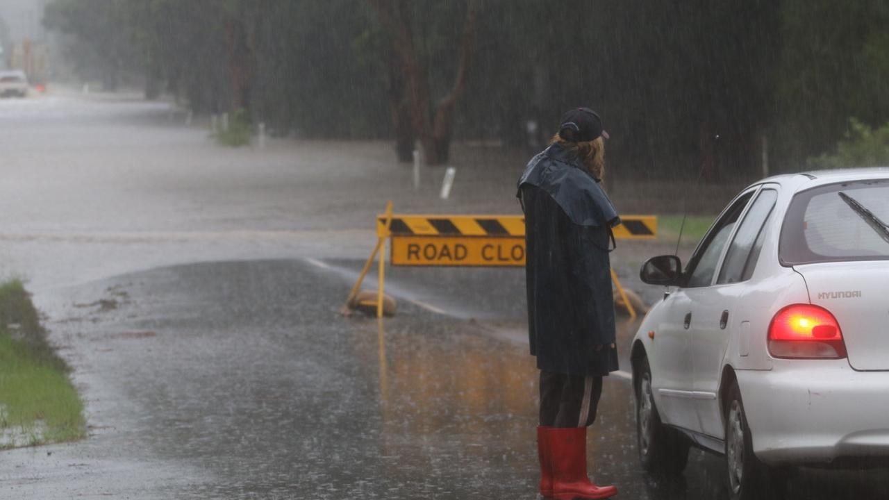 Londonderry resident, Carol, flags down cars ignoring road closed signs as floodwaters threaten her home on March 2, 2022. Picture: Jake McCallum