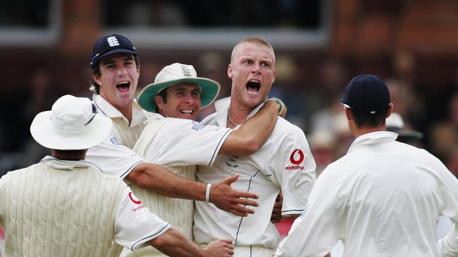 Andrew Flintoff is embraced by captain Michael Vaughan and Kevin Pietersen (L) .