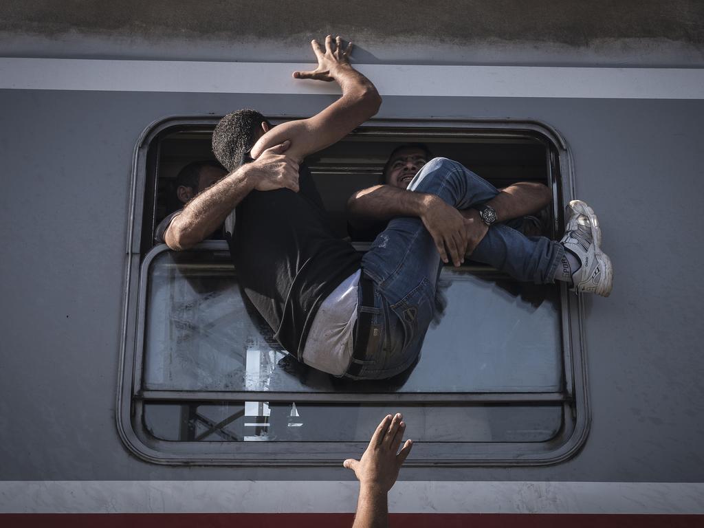 “Reporting Europe’s Refugee Crisis” by photographer Sergey Ponomarev for The New York Times which won the first prize in the General News Stories category shows refugees attempting to board a train headed to Zagreb, Croatia in Tovarnik, Croatia, 18 September 2015. (Sergey Ponomarev for The New York Times, World Press Photo via AP)