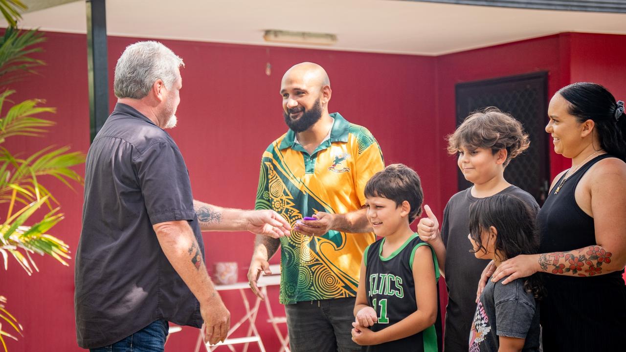 Yilli Rreung Housing Aboriginal Corporation Operation Manager John Adams hands the keys of a new home to Darwin parents Sarah and Murray Liddle with their children Bradley, 12, Orlando, 9, and six-year-old Brooklyn.