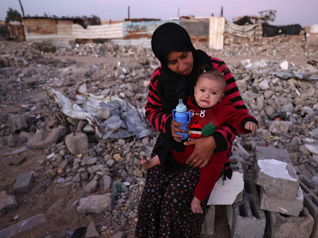 A woman feeds her child amid the rubble of destroyed buildings at a makeshift camp for displaced Palestinians in Khan Yunis, in the southern Gaza Strip. Picture: Bashar Taleb/AFP