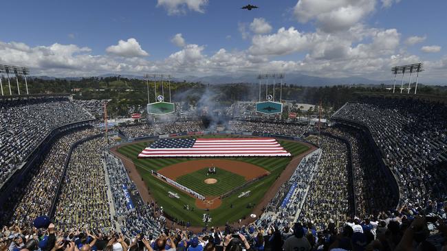 Fans cheer as a Boeing C-17 Globemaster III conducts a flyover during the national anthem on opening day at Dodger Stadium.