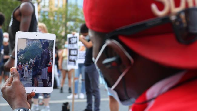 Samuel Wilson, a Black Lives Matter activist, records a video as Terrea Mitchell speaks during a vigil for Jacob Blake on August 25 in New York City.