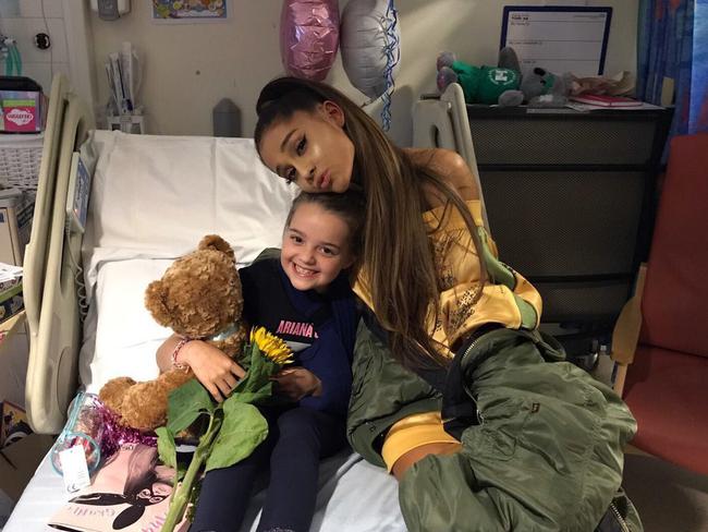 Grande sits with Lily Thorpe, an eight-year-old fan who was inured after her concert. Picture: Facebook