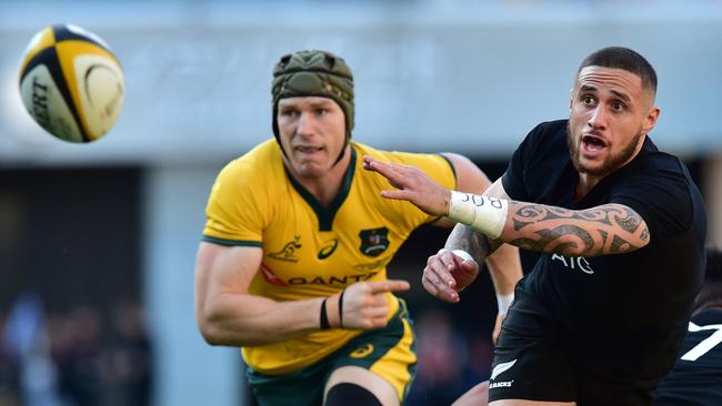 New Zealand's scrumhalf TJ Perenara (R) passes the ball as Australia's David Pocock (L) looks on during the Bledisloe Cup rugby union Test match between the New Zealand All Blacks and Australia at Yokohama International Stadium in Yokohama on October 27, 2018. (Photo by Kazuhiro NOGI / AFP)